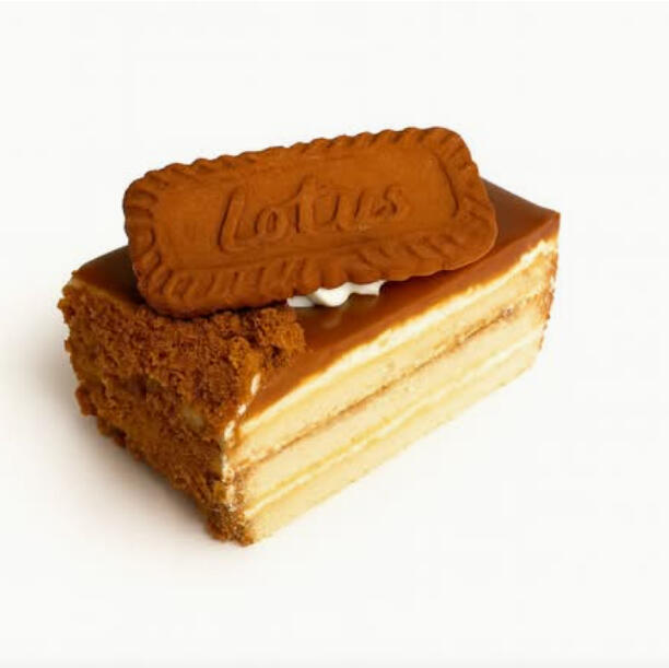 Lotus Cake Slice $7.49 Layered cake slice coated in caramelized biscuit glaze, topped with a Lotus biscuit and biscuit crumbs.