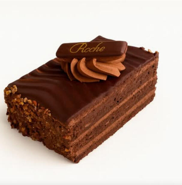 Ferrero Rocher Cake Slice $7.49 Ferrero Rocher–inspired layered chocolate cake with silky chocolate cream, a smooth chocolate topping, and crunchy nut garnish.